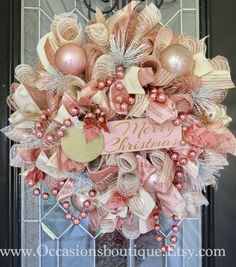 a pink and gold christmas wreath on the front door for someone's new home