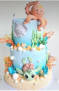 there is a blue cake with an octopus on top and sea animals on the bottom