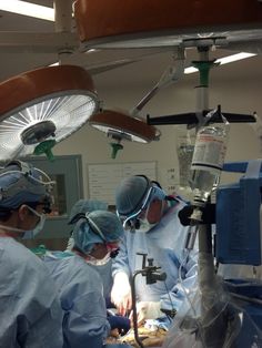 three doctors are performing surgery in an operating room