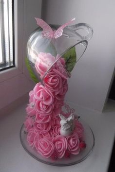 a vase filled with pink flowers on top of a white counter next to a window