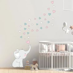 a baby's room with an elephant and hearts wall decal on the wall