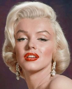 marilyn monroe is wearing red lipstick and gold earring earrings in the 1950's