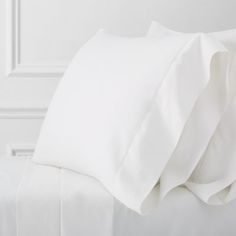 the white sheets and pillow cases are neatly made