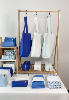 blue and white handbags are on display at a table with other items in front of it