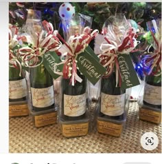 several bottles of wine sitting on top of a table next to a christmas tree with candy canes in them