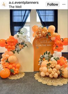 two oranges and white balloons are on display in front of an arch that says, the event planners follow