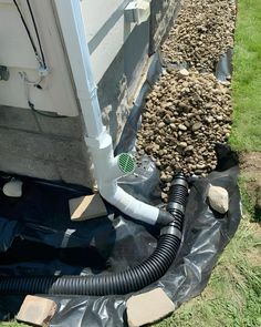 an image of a drain in the ground that is being installed to a house's foundation