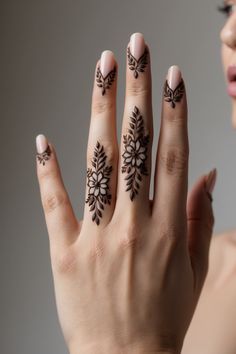 a woman's hand with hennap on it and a flower design on the middle finger