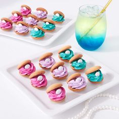 two white plates with cookies and cupcakes on them next to a blue drink