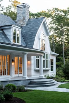 a white house with large windows and steps leading up to it