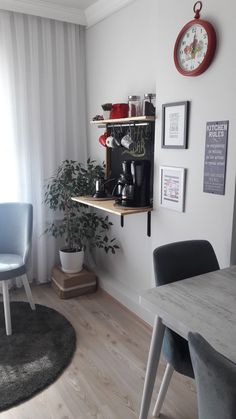 a room with a table, chair and clock on the wall