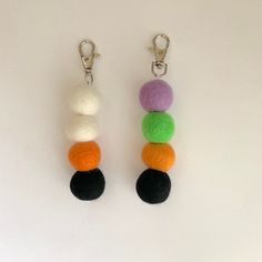 two keychains with different colored balls attached to each other on a white surface