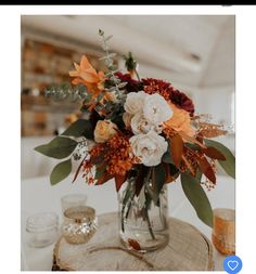 a vase filled with flowers sitting on top of a wooden table next to other items