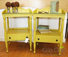 two yellow end tables with glass tops on display in front of a white wall and wood floor