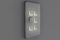 an illuminated light switch on the wall in a room with grey walls and flooring