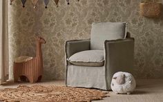 a baby's room with a rocking chair, stuffed animal and wall hangings