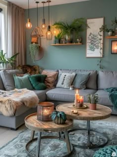 a living room filled with lots of furniture and plants on the wall above it's coffee table