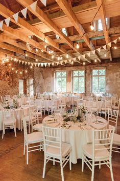 an indoor venue with tables and chairs set up for a wedding