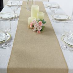 the table is set with candles, flowers and place settings for two people to sit at