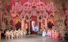 a group of people standing on top of a stage in front of an ornate archway