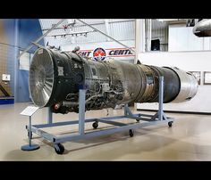 a large jet engine sitting on top of a metal stand in a museum like setting