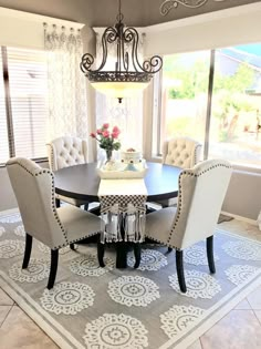 a dinning room table with chairs and a chandelier hanging from the ceiling