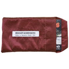 the brand's logo is displayed on this maroon pouch with brown leather linings