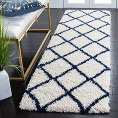 a white and blue rug on the floor in front of a door with potted plants