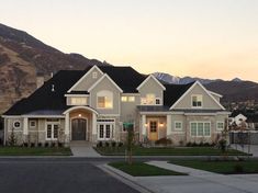 a large white house with mountains in the background