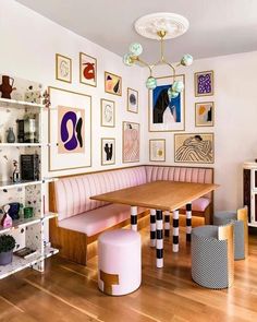 a dining room with pink booths and pictures on the wall