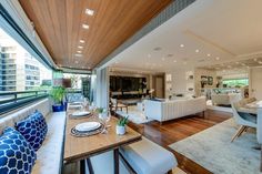 a living room filled with furniture next to a window covered in lots of glass and wood