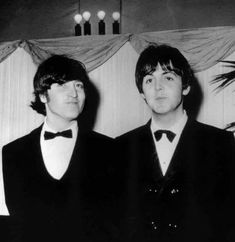 two men in tuxedos standing next to each other