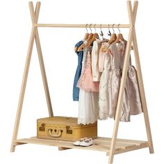 a wooden rack with clothes hanging on it and a suit case next to the rack