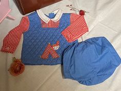 Vintage 70's Tiny Tots Originals, Blue/Red checkered Quilted infant set, 9-12 months, Looks like Raggedy Ann & Andy fabric & style! Adorable blue quilted top w/red & white checkered sleeves, button on cuff/wrist, white collar w/red stitiching & 2 buttons in front, Blue Quilted top stitched in red, cute stitched patch of red & white checkered child, back opening w/3 buttons, (sleeves sewn into quilted top, one piece)  Blue rubber bottom, elastic waist, rubber pant lining, pulls up (no snap button opening) Infant approx. 9-12 months (no size tag), maker tag-Tiny Tots Originals, In Beautiful Vintage Coondition, fabric still feels crisp & colors still vibrant! *shoulder to shoulder-9'inches across, *Chest-11' inches across, *Shoulder to hem-11' inches, *Rubber pant-6' inches, waist stretches u Plaid Cotton Playtime Set, Cute Plaid Cotton Sets, Cute Gingham Sets For Playtime, Cute Plaid Playtime Sets, Vintage Sets For Spring Playtime, Cute Gingham Playtime Sets, Vintage Playtime Sets For Spring, Vintage Blue Long Sleeve Sets, Fitted Gingham Cotton Sets