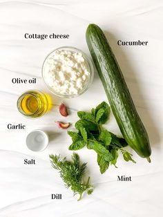 cucumbers, herbs and other ingredients on a white surface