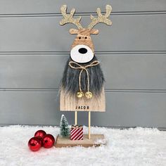 a wooden sign with a reindeer head and antlers on it in front of a garage door