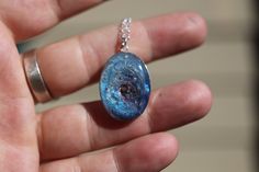 "If you are searching for a truly unique and breathtaking memorial gift, look no further than our milky way pendants! These cremation galaxy necklaces are handcrafted for you with the ashes you provide. Each swirling, shimmery galaxy is set in a 18x25mm oval sterling silver pendant and hangs from your choice of sterling silver chain. These galactic necklaces are built in layers to give them as much depth as possible. In the comments box, please note how defined you would like the \"swirl\" to be Celestial Style Necklace With Polished Finish As Gift, Keepsake Jewelry Round Pendant With Natural Inclusions, Keepsake Round Pendant With Natural Inclusions, Celestial Style Oval Jewelry Gift, Celestial Style Oval Jewelry For Gifts, Fusion Style Polished Finish Necklaces For Gifts, Unique Memorial Necklace With Round Pendant, Unique Round Pendant Necklace For Memorial, Unique Blue Jewelry With Natural Inclusions