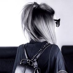 the back of a woman's head with sunglasses and a purse on her shoulder