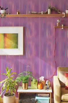 a living room filled with furniture and a painting on the wall next to a table