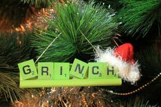 a christmas ornament that says grinch hanging from a pine tree with the word grinch on it