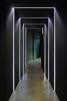 an empty hallway is lit up with neon lights