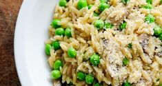 a white bowl filled with pasta and peas