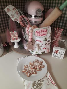 some cookies are on a plate next to a mixer and utensils in a kitchen