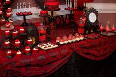 a table topped with lots of red and black desserts