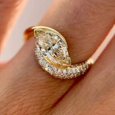 a woman's hand with a yellow and white diamond ring on top of her finger