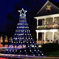 a lit up christmas tree in front of a house