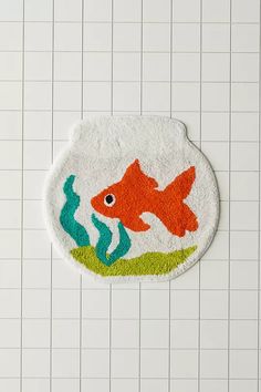 a fish rug is on the floor in front of a tiled wall with white tiles