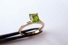 "Stunning set of 2 14K yellow gold stacking rings - a peridot solitaire ring and a unique wedding band. This set consists of 2 beautiful solid gold rings: The 1st is a rustic wedding band, with an uneven design that gives it a distinctive \"handmade\" look. It is forever changing, never looking the same. The 2nd ring has a sparkling green rectangular peridot set in a beautiful base. This can be an awesome engagement ring. This modern bridal ring set is perfect for a boho bride. The rings have a Green Engagement Ring Gold, Green Engagement Ring, Peridot Ring Gold, Gold Peridot Ring, Yellow Gold Stacking Rings, Green Engagement Rings, Gold Ring Women, Antique Style Jewelry, Rustic Wedding Bands