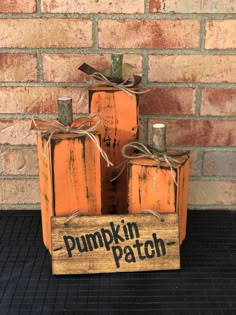 three pumpkins are stacked on top of each other in a wooden box that says pumpkin patch