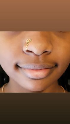 a woman's nose with a gold nose pin in the shape of a heart